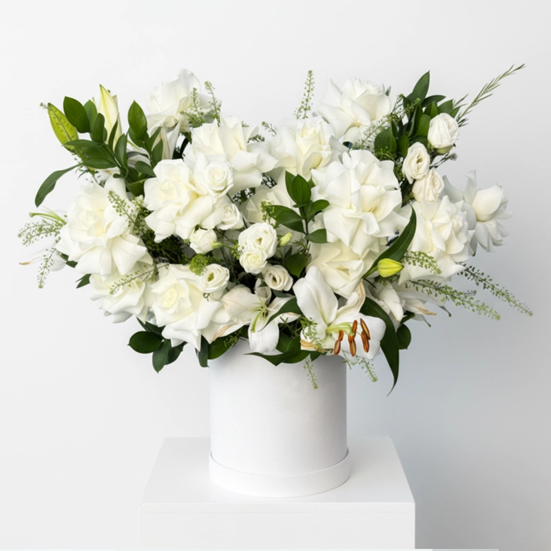 Luxury white roses and lilies flower arrangement in a tall round white box, delivered in the UAE by onlineflowershop.ae